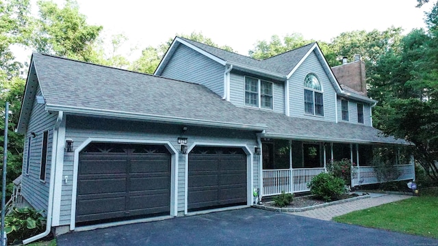 625 Lakeview Rd, Orange, CT 06477 - view of front of home featuring a chimney, an attached garage, covered porch, driveway, and roof with shingles