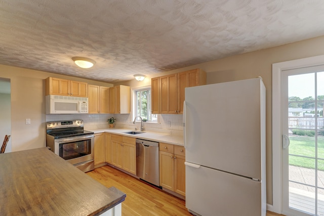 23 Sun St, Enfield, CT 06082 - kitchen featuring stainless steel appliances, decorative backsplash, a textured ceiling, light wood-style flooring, and light countertops