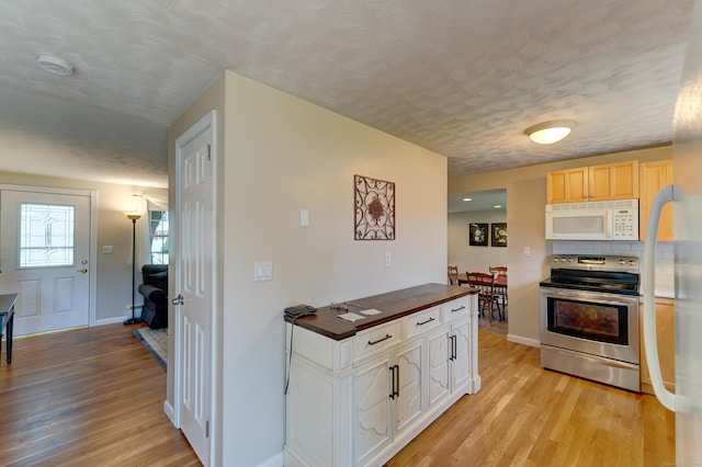 23 Sun St, Enfield, CT 06082 - kitchen with stainless steel electric stove, white microwave, light wood-type flooring, butcher block counters, and a textured ceiling