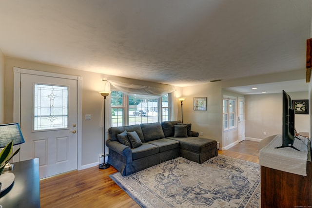 23 Sun St, Enfield, CT 06082 - living room with light wood-style floors and a baseboard radiator