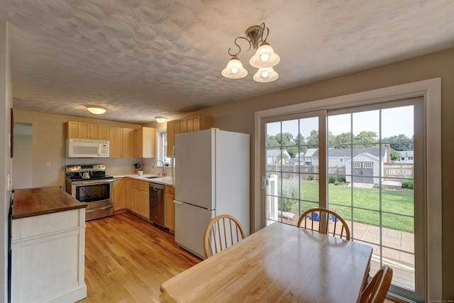 23 Sun St, Enfield, CT 06082 - kitchen featuring stainless steel appliances, light wood finished floors, a chandelier, tasteful backsplash, and light brown cabinetry