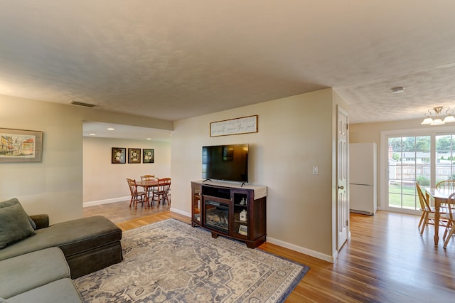 23 Sun St, Enfield, CT 06082 - living room with wood finished floors, a chandelier, a textured ceiling, and recessed lighting