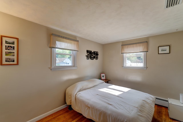 23 Sun St, Enfield, CT 06082 - bedroom featuring baseboard heating, multiple windows, and wood finished floors