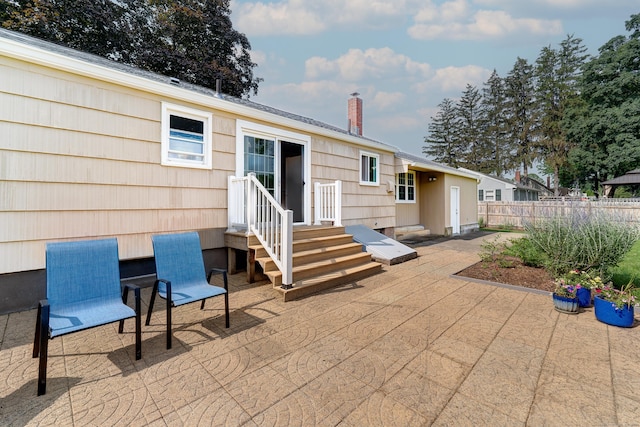 23 Sun St, Enfield, CT 06082 - rear view of house featuring entry steps, a patio area, and a chimney