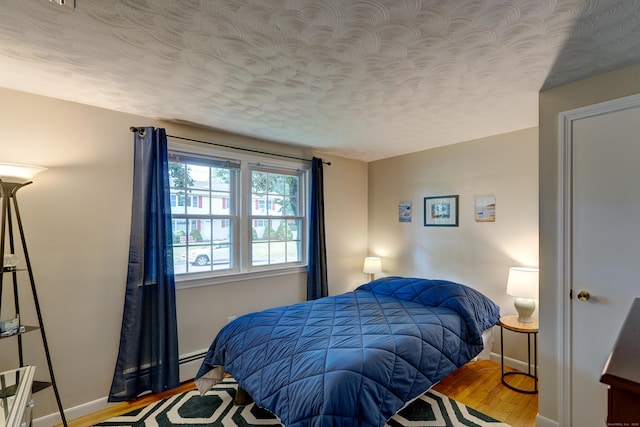 23 Sun St, Enfield, CT 06082 - bedroom featuring wood finished floors, a textured ceiling, and baseboard heating