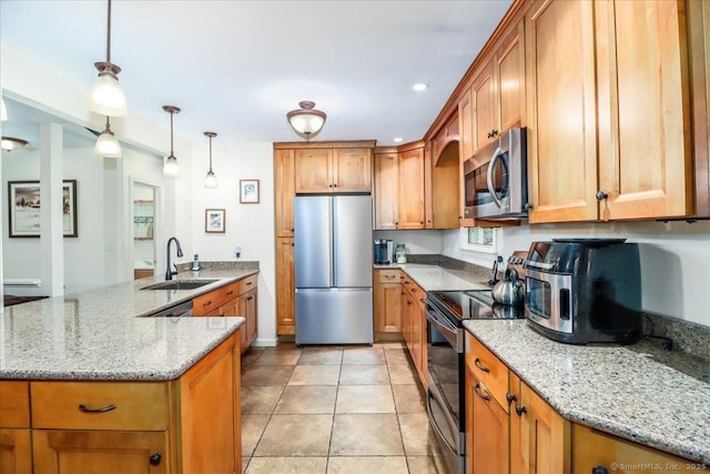 135 Green Pond Rd, Sherman, CT 06784 - kitchen with stainless steel appliances, brown cabinetry, a peninsula, light stone counters, and hanging light fixtures