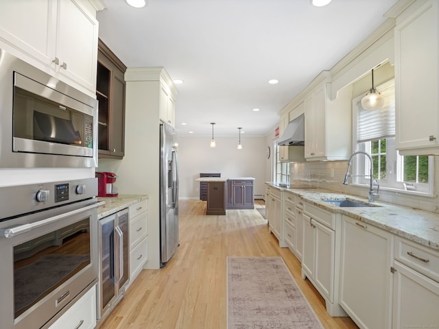 22 Rocky Ridge Dr, Trumbull, CT 06611 - kitchen with appliances with stainless steel finishes, light wood-type flooring, beverage cooler, decorative backsplash, and hanging light fixtures