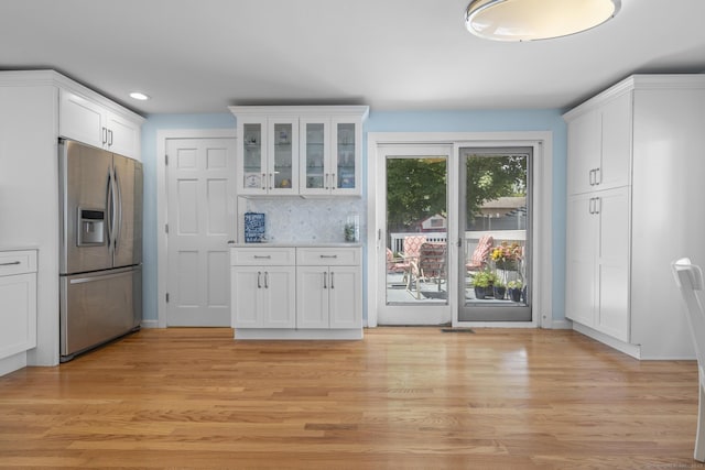 35 Lawrence Ave, Milford, CT 06460 - kitchen with stainless steel refrigerator with ice dispenser, white cabinetry, glass insert cabinets, light wood-type flooring, and tasteful backsplash
