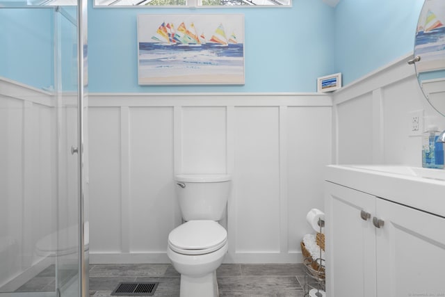 35 Lawrence Ave, Milford, CT 06460 - full bathroom with a decorative wall, vanity, a stall shower, a wainscoted wall, and wood finished floors