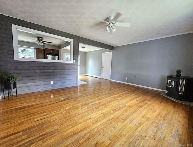 108 French St, Bristol, CT 06010 - unfurnished living room featuring ceiling fan, a wood stove, and wood finished floors