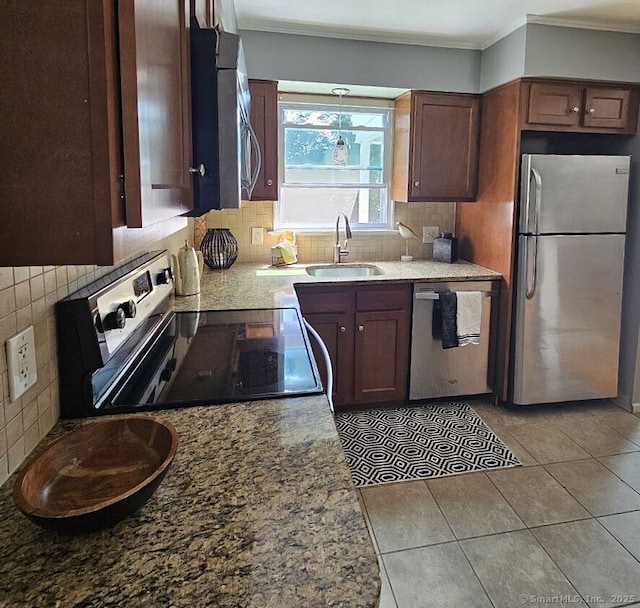 108 French St, Bristol, CT 06010 - kitchen with stainless steel appliances, decorative backsplash, crown molding, light tile patterned floors, and light stone counters