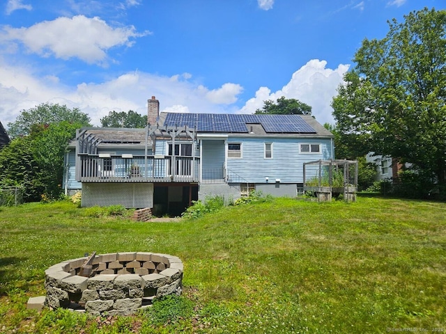 108 French St, Bristol, CT 06010 - back of property with a fire pit, a deck, a chimney, solar panels, and a yard