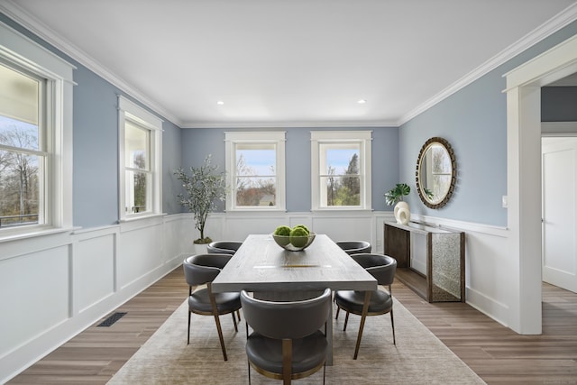 433 Belden Hill Rd, Wilton, CT 06897 - dining space featuring wood finished floors, crown molding, a decorative wall, and wainscoting