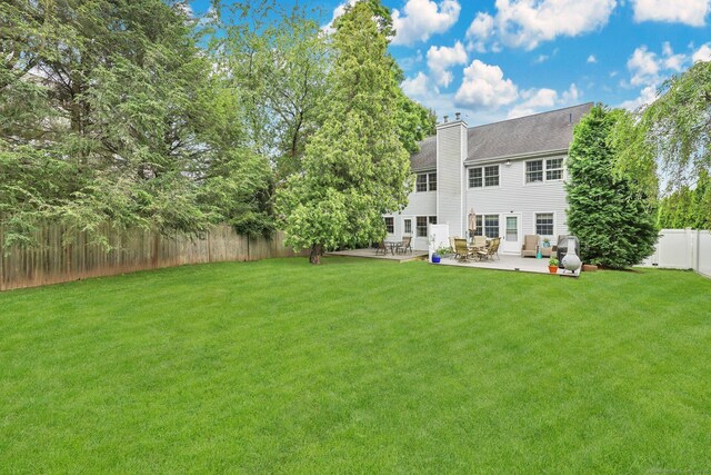 668 Kings Hwy W Unit 668, Fairfield, CT 06890 - back of house with a fenced backyard, a chimney, and a patio