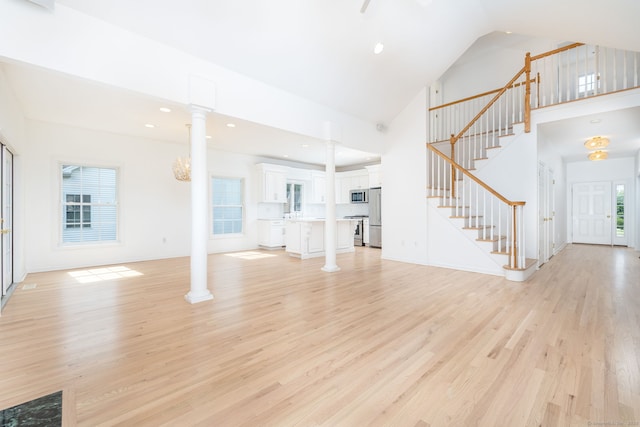 20 Stony Creek Rd Unit 20, Southington, CT 06479 - unfurnished living room with high vaulted ceiling, decorative columns, light wood-type flooring, stairs, and recessed lighting
