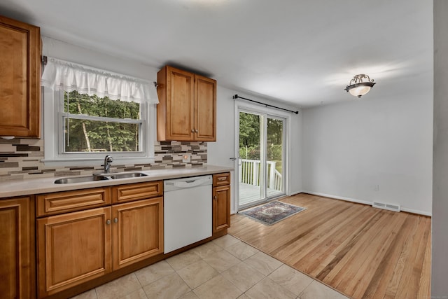 43 Kanter Dr, Vernon, CT 06066 - kitchen featuring dishwasher, backsplash, light countertops, brown cabinets, and light tile patterned floors