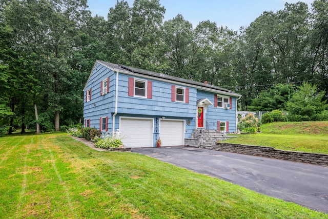 43 Kanter Dr, Vernon, CT 06066 - split foyer home with driveway, an attached garage, a front lawn, solar panels, and view of wooded area