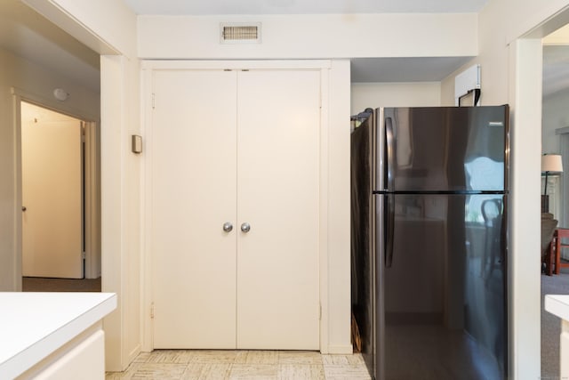 512 Heritage Vlg Unit B, Southbury, CT 06488 - kitchen with freestanding refrigerator, white cabinetry, light countertops, and light floors