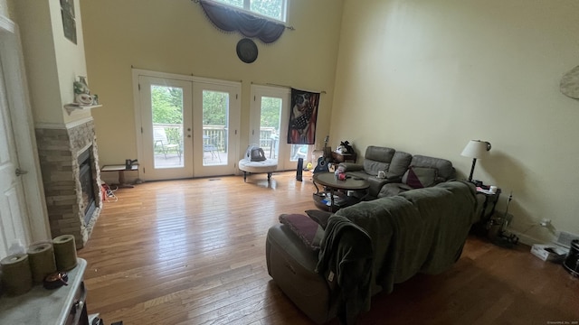 49 Ratlum Mountain Rd, Barkhamsted, CT 06063 - living area with a fireplace, wood-type flooring, french doors, and a towering ceiling