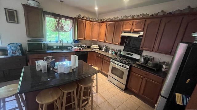 49 Ratlum Mountain Rd, Barkhamsted, CT 06063 - kitchen featuring stainless steel appliances, under cabinet range hood, a breakfast bar area, light tile patterned floors, and a center island