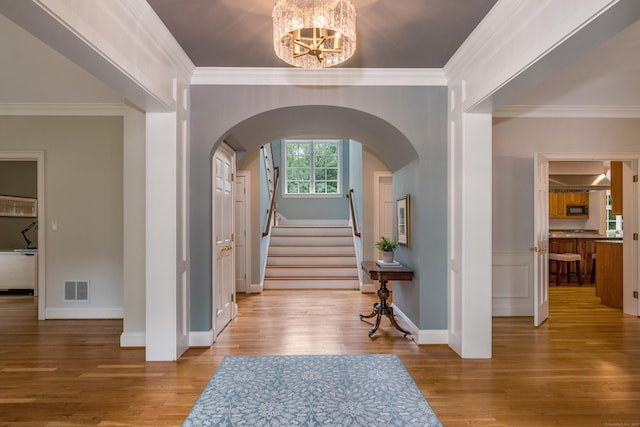 4 Brighton Ln, Simsbury, CT 06070 - entryway with arched walkways, a chandelier, wood finished floors, ornamental molding, and stairs