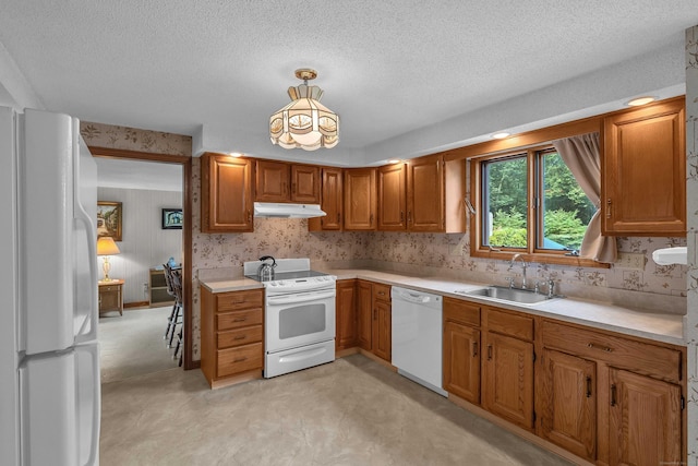 21 Briarcliffe Trl, Old Saybrook, CT 06475 - kitchen with white appliances, under cabinet range hood, light countertops, brown cabinetry, and a chandelier