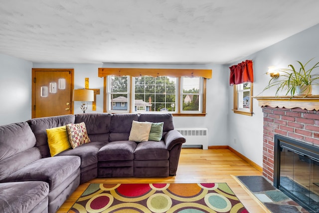 141 Orchard St, Meriden, CT 06450 - living room with radiator heating unit, light wood finished floors, plenty of natural light, and a fireplace