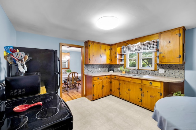 141 Orchard St, Meriden, CT 06450 - kitchen with black appliances, light countertops, brown cabinets, and backsplash