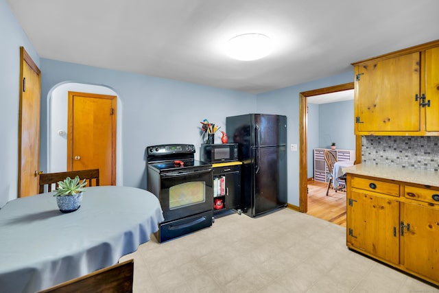 141 Orchard St, Meriden, CT 06450 - kitchen with black appliances, light countertops, arched walkways, tasteful backsplash, and brown cabinets