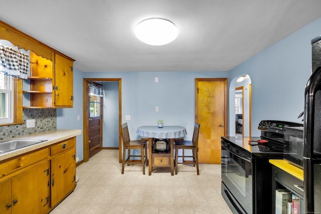 141 Orchard St, Meriden, CT 06450 - kitchen with black electric range, light countertops, brown cabinets, backsplash, and open shelves
