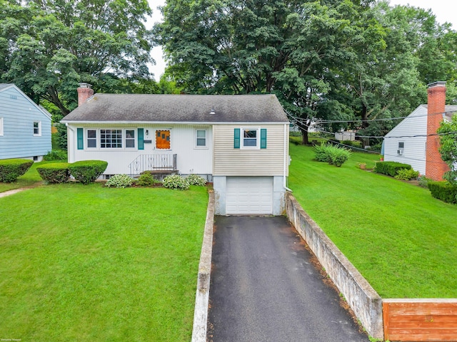 141 Orchard St, Meriden, CT 06450 - view of front of property with a garage, asphalt driveway, a front yard, and a chimney
