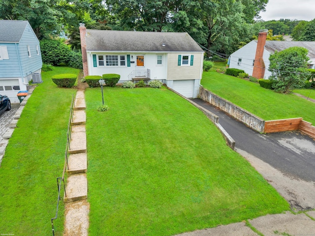 141 Orchard St, Meriden, CT 06450 - view of front of house featuring a garage, a chimney, asphalt driveway, a front lawn, and a shingled roof