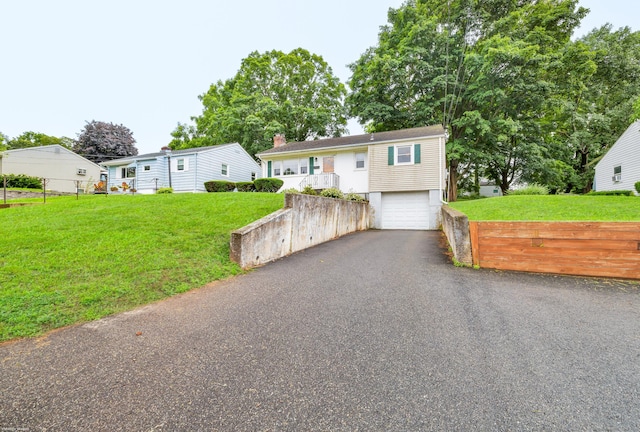 141 Orchard St, Meriden, CT 06450 - view of front of house featuring a garage, asphalt driveway, and a front yard