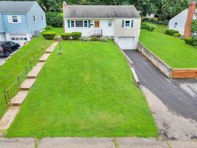 141 Orchard St, Meriden, CT 06450 - view of front facade with a garage, a chimney, asphalt driveway, and roof with shingles