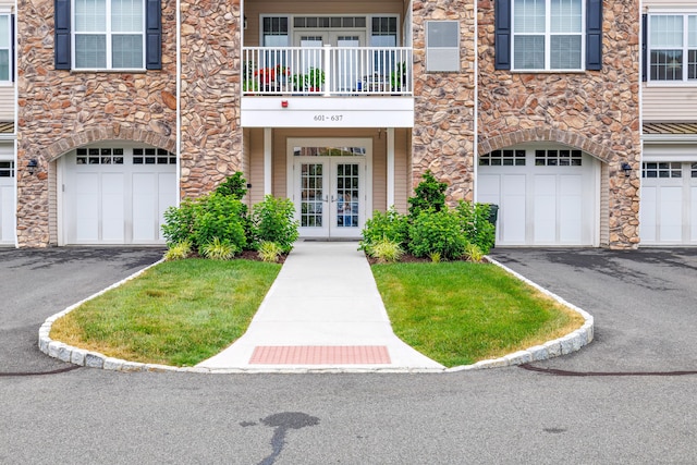 605 Brookside Ct Unit 605, Newtown, CT 06470 - property entrance with french doors, stone siding, a garage, and driveway