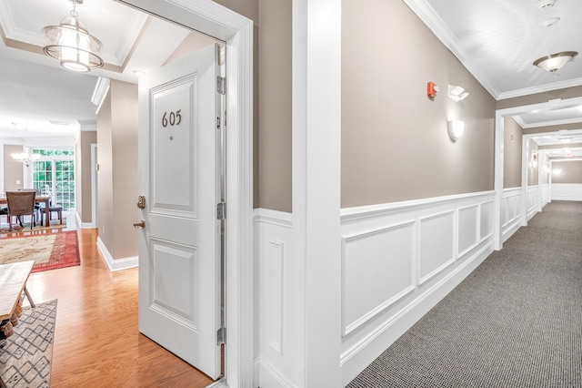 605 Brookside Ct Unit 605, Newtown, CT 06470 - hall featuring crown molding, a chandelier, a wainscoted wall, light wood-style flooring, and a decorative wall