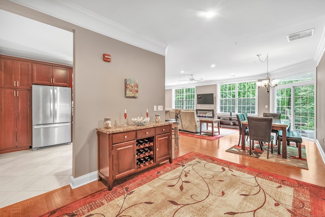 605 Brookside Ct Unit 605, Newtown, CT 06470 - kitchen with freestanding refrigerator, ornamental molding, light wood finished floors, light stone counters, and a chandelier