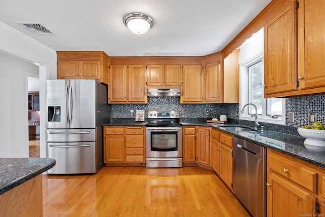 120 Plank Hill Rd, Simsbury, CT 06070 - kitchen with appliances with stainless steel finishes, under cabinet range hood, light wood-style flooring, backsplash, and brown cabinetry