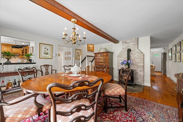 25 Spring St, Chester, CT 06412 - dining space with a wood stove, hardwood / wood-style flooring, beam ceiling, and a chandelier