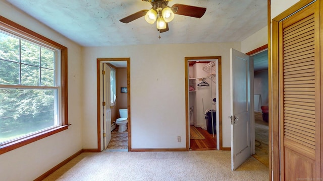 183 Schroback Rd, Plymouth, CT 06782 - unfurnished bedroom with multiple windows, light colored carpet, connected bathroom, and a walk in closet