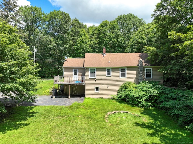 183 Schroback Rd, Plymouth, CT 06782 - rear view of property featuring a wooden deck, a lawn, a patio area, and a chimney