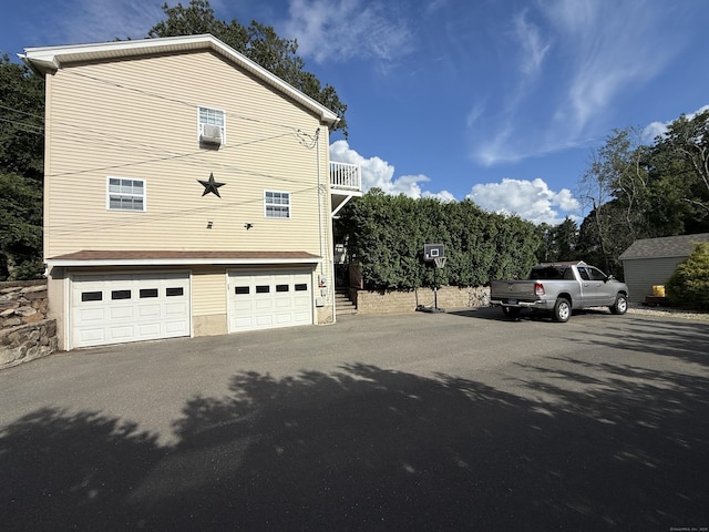 7 School St, Burlington, CT 06013 - view of side of property with a balcony, asphalt driveway, and a garage