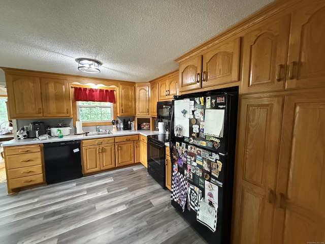 7 School St, Burlington, CT 06013 - kitchen featuring black appliances, light countertops, a textured ceiling, light wood-type flooring, and brown cabinets
