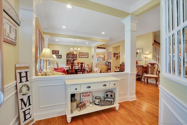33 Wadsworth Ln Unit 33, Wallingford, CT 06492 - bar area featuring decorative columns, light wood-type flooring, a wainscoted wall, a chandelier, and hanging light fixtures