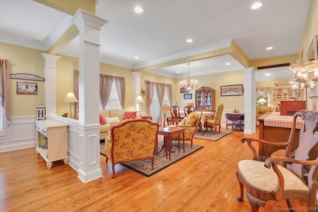 33 Wadsworth Ln Unit 33, Wallingford, CT 06492 - living area featuring decorative columns, ornamental molding, light wood-style flooring, a decorative wall, and wainscoting