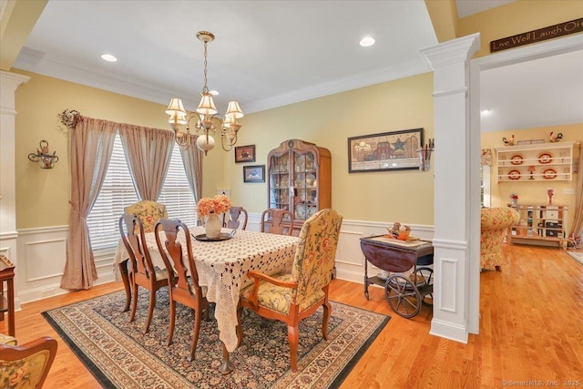 33 Wadsworth Ln Unit 33, Wallingford, CT 06492 - dining room with ornate columns, a chandelier, a wainscoted wall, light wood-style flooring, and ornamental molding