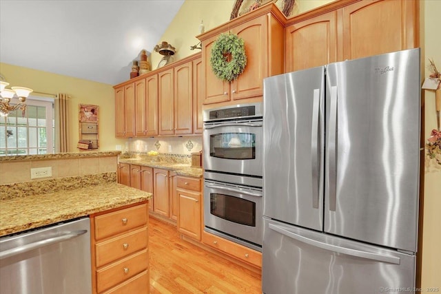 33 Wadsworth Ln Unit 33, Wallingford, CT 06492 - kitchen featuring stainless steel appliances, light wood-style floors, light stone countertops, a chandelier, and light brown cabinetry