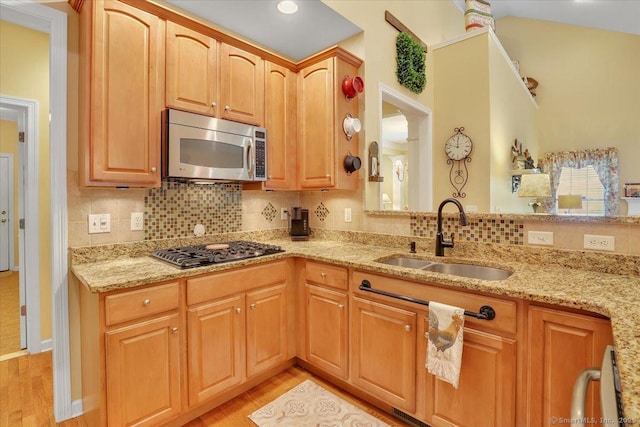 33 Wadsworth Ln Unit 33, Wallingford, CT 06492 - kitchen with appliances with stainless steel finishes, light stone counters, light wood-type flooring, and decorative backsplash