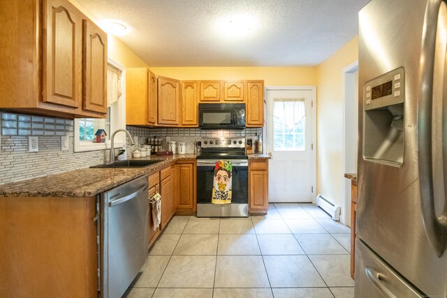 82 Pleasant St, Thomaston, CT 06787 - kitchen with appliances with stainless steel finishes, a baseboard radiator, decorative backsplash, a textured ceiling, and light tile patterned floors