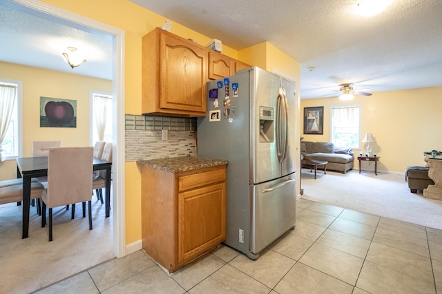 82 Pleasant St, Thomaston, CT 06787 - kitchen featuring light colored carpet, stainless steel fridge, ceiling fan, light tile patterned flooring, and backsplash